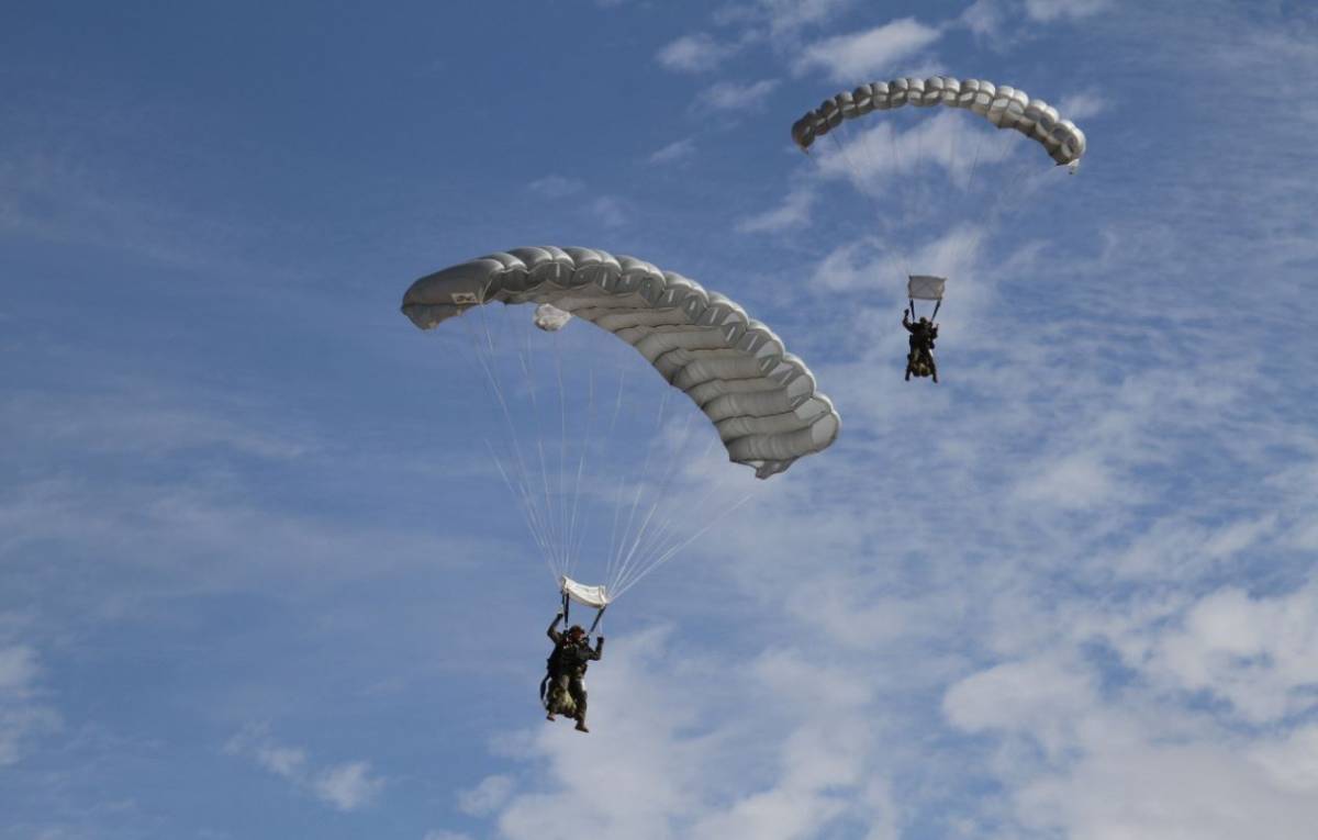 2 miembros de la CRAV llegando a tierra, utilizando sus paracaídas cuadrangulares de salto manual. 2 miembros de la CRAV llegando a tierra, utilizando sus paracaídas cuadrangulares de salto manual.