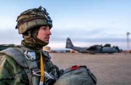 Un miembro de la BRIPAC est� a punto de embarcar en un avi�n de transporte, al fondo se ve un C-130J de la USAFE. (Foto US Army)