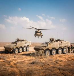 Dos de los 8x8 �Eitan� de la IDF, detr�s se ve un helic�ptero UH-60 �Yanshuf� de dicha fuerza. (foto IDF)