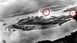 Figura 1. Fotograf�a tomada desde un avi�n japon�s poco despu�s del comienzo del ataque a Pearl Harbor. Un torpedo acaba de alcanzar al USS West Virginia en el lado m�s alejado de la isla Ford (centro). Aviones japoneses son visibles en el centro (sobre la Isla Ford) y a la derecha, sobre el Astillero Naval